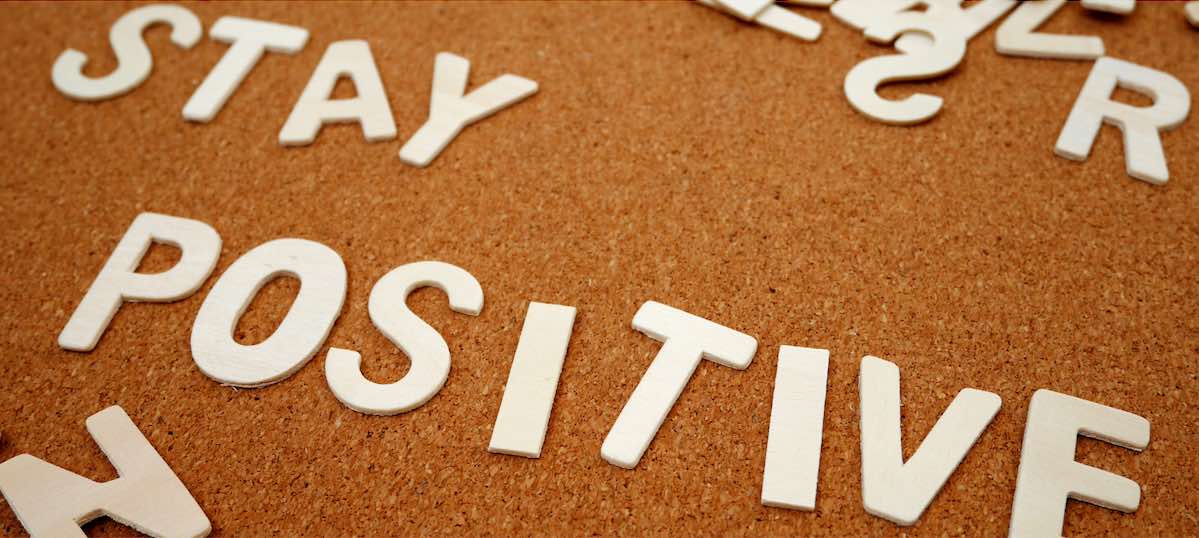 Cork board with Stay Positive spelt in white letters